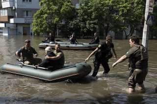 Une femme est évacuée d'un quartier inondé à Kherson, dans le sud de l'Ukraine, après la destruction partielle du barrage de Kakhovka.